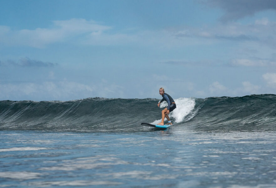 surfer guy catching his first wave during his first surf in nusa lembongan