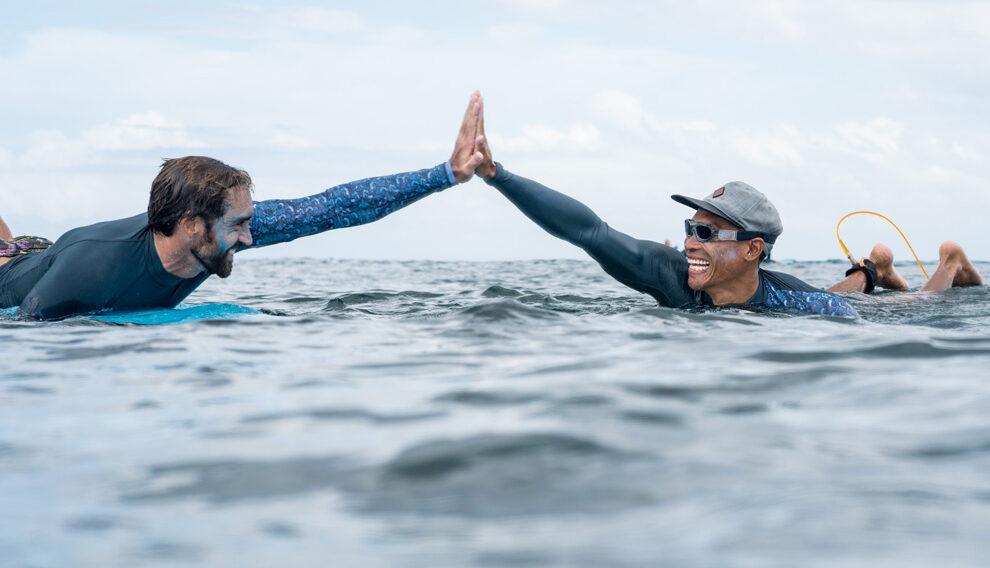 surfing mentor with student in the water